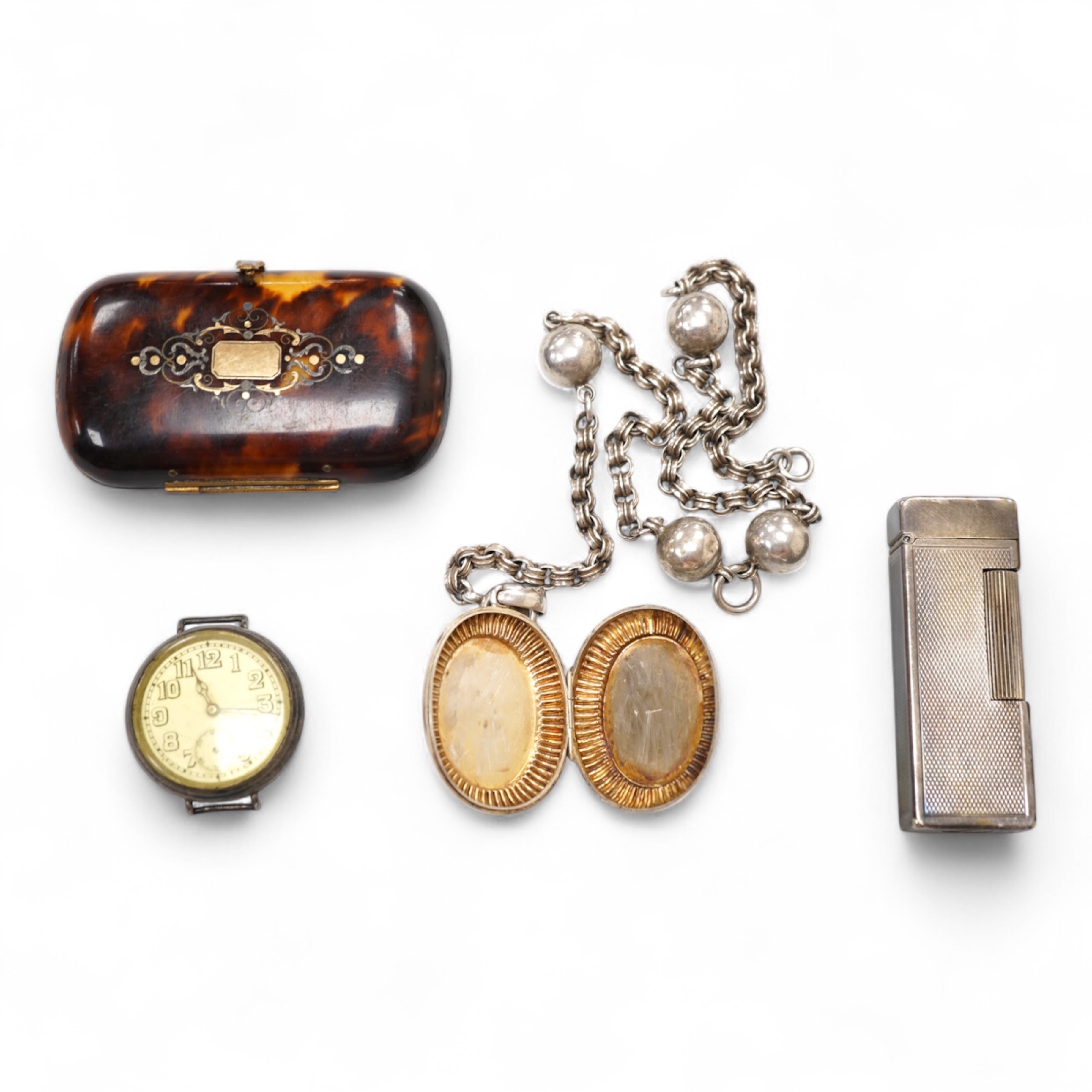 An early 20th century white metal oval locket, 40mm, on a silver chain, a silver plated Dunhill lighter, in Dunhill box, a white metal cased manual wind wrist watch and a tortoiseshell purse.